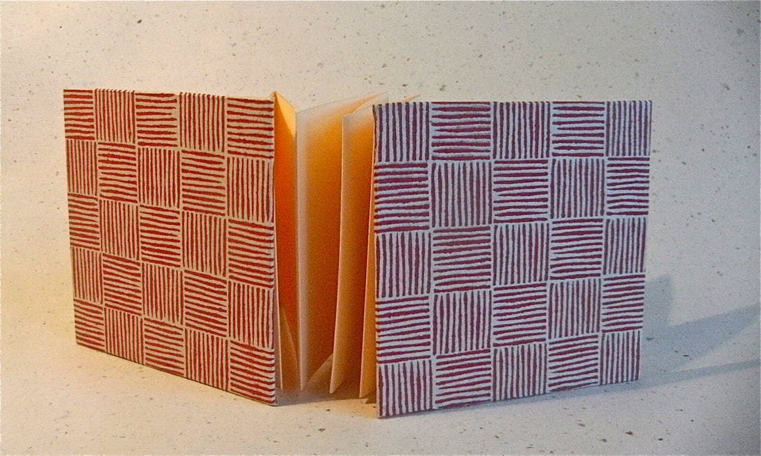 handmade concertina pocketbook with cream pages and red geometric grid design covers